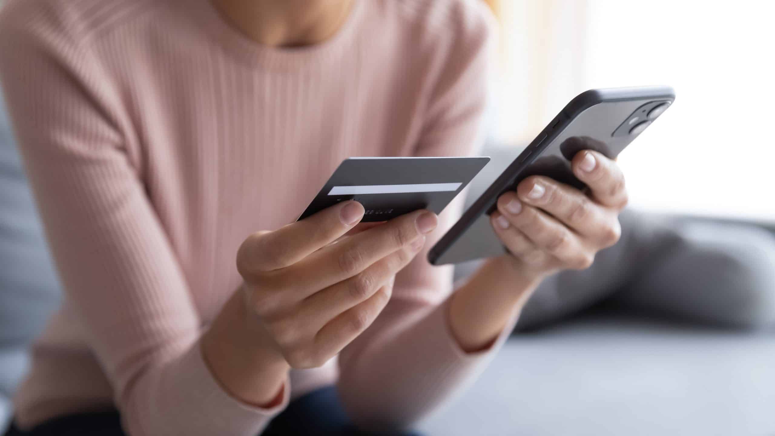 woman holding iphone and credit card